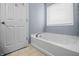 Bathroom featuring a white bathtub, neutral tile flooring, and a window at 5209 Twin Bridge Blvd, Indianapolis, IN 46239