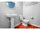 Modern bathroom featuring a sleek pedestal sink, toilet, and decorative wall art at 5209 Twin Bridge Blvd, Indianapolis, IN 46239
