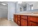 Bathroom featuring double sinks, dark wood cabinets, and neutral tile flooring at 5209 Twin Bridge Blvd, Indianapolis, IN 46239