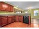 Kitchen featuring dark wood cabinets, a black dishwasher, and a stainless steel sink for easy cleanup at 5209 Twin Bridge Blvd, Indianapolis, IN 46239
