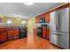 Bright kitchen with stainless steel refrigerator, dark wood cabinets, wood flooring, and modern black microwave and stove at 5209 Twin Bridge Blvd, Indianapolis, IN 46239
