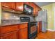 Modern kitchen featuring dark wood cabinets, stainless steel appliances, modern backsplash and lots of countertop space at 5209 Twin Bridge Blvd, Indianapolis, IN 46239
