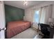 Bedroom featuring a bed, a desk, a green accent wall, and natural light coming in from the window at 5240 Regency Dr, Columbus, IN 47203