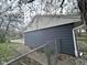 A view of the home's blue siding, fence and well-kept landscaping, adding to the curb appeal and privacy at 5240 Regency Dr, Columbus, IN 47203