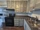 The kitchen offers painted cabinets, stainless steel sink, and sleek, black appliances at 5240 Regency Dr, Columbus, IN 47203