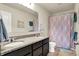 Well-lit bathroom featuring double sinks with granite countertops and a shower with a colorful curtain at 5247 Crowley Pkwy, Whitestown, IN 46075