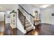 Elegant entryway with wood floors, staircase, and a view into the living space, showcasing a blend of style and functionality at 5247 Crowley Pkwy, Whitestown, IN 46075