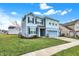 Inviting two-story home with blue siding, manicured lawn, concrete driveway, and attached two-car garage at 5247 Crowley Pkwy, Whitestown, IN 46075
