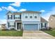 Charming two-story home featuring blue siding, black shutters, a concrete driveway, and an attached two-car garage at 5247 Crowley Pkwy, Whitestown, IN 46075