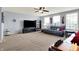 Bright living room featuring neutral carpet, a ceiling fan, and a comfortable sofa with an entertainment center at 5247 Crowley Pkwy, Whitestown, IN 46075