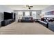 A spacious living room showcases neutral carpet, a ceiling fan, and comfortable seating with a large entertainment center at 5247 Crowley Pkwy, Whitestown, IN 46075