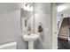 Neutral powder room with pedestal sink, mirror, and staircase nearby at 5247 Crowley Pkwy, Whitestown, IN 46075