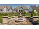 Inviting backyard featuring a stylish stone firepit, seating, well-manicured lawn, and scenic community views at 528 Dylan Dr, Carmel, IN 46032