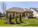 Backyard with lush lawn, mature trees, a stone fountain, and a retaining wall at 528 Dylan Dr, Carmel, IN 46032