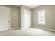 Neutral bedroom featuring a window, carpet flooring, neutral paint, closet with sliding doors, and two doors at 528 Dylan Dr, Carmel, IN 46032