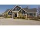 Community clubhouse exterior showcases stone and siding, with covered entryway, and meticulously maintained landscaping at 528 Dylan Dr, Carmel, IN 46032