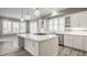 Spacious kitchen features white cabinets, a large island with cooktop, and modern pendant lighting at 528 Dylan Dr, Carmel, IN 46032