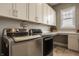 Convenient laundry room featuring front loading washer and dryer, white cabinetry, and countertop at 528 Dylan Dr, Carmel, IN 46032