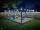 Backyard patio illuminated at night, featuring a fire pit, swing set, and outdoor seating at 6225 Roberts Creek Ln, Indianapolis, IN 46221