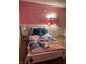 Bright bedroom with a playful design, featuring a pink wall and 'stitch' themed bedding at 6225 Roberts Creek Ln, Indianapolis, IN 46221