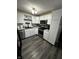 Modern kitchen featuring white cabinets, granite countertops, stainless appliances, and dark wood flooring at 6225 Roberts Creek Ln, Indianapolis, IN 46221
