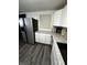 Well-lit kitchen area with stainless refrigerator, granite countertops, and updated white cabinets at 6225 Roberts Creek Ln, Indianapolis, IN 46221