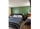 Bedroom with sleek black bed frame, and decorative dark-green wainscoting wall at 6225 Roberts Creek Ln, Indianapolis, IN 46221