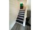 Staircase featuring stylish patterned tile risers and sleek, dark treads leading to the next level at 6225 Roberts Creek Ln, Indianapolis, IN 46221