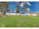 Spacious backyard with green lawn, storage shed, and trees creating a serene outdoor space at 6501 Meadowlark Dr, Indianapolis, IN 46226