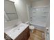 Well-lit bathroom featuring a shower-tub combo and modern vanity with wood-look cabinets at 6501 Meadowlark Dr, Indianapolis, IN 46226