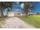 Single-story home featuring a gravel driveway, attached garage, and a well-manicured lawn at 6501 Meadowlark Dr, Indianapolis, IN 46226