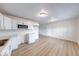 Spacious kitchen featuring white cabinets, new laminate flooring, and modern appliances including a microwave at 6501 Meadowlark Dr, Indianapolis, IN 46226