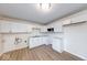 Clean kitchen with white cabinets, new laminate flooring, and modern appliances including a microwave at 6501 Meadowlark Dr, Indianapolis, IN 46226