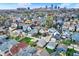 An aerial shot of a neighborhood displays a variety of colorful homes and mature trees with a cityscape in the background at 715 Cottage Ave, Indianapolis, IN 46203