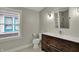 Modern bathroom featuring a wood vanity with a white countertop and white penny tile floors at 715 Cottage Ave, Indianapolis, IN 46203