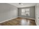 A bright bedroom with a ceiling fan, hardwood floors, a window and a mini AC unit at 715 Cottage Ave, Indianapolis, IN 46203
