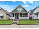Charming home with a welcoming front porch, green lawn and beautifully maintained landscaping at 715 Cottage Ave, Indianapolis, IN 46203