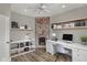 Well-lit home office with a brick fireplace, a desk, and shelving at 715 Cottage Ave, Indianapolis, IN 46203