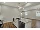 Open kitchen featuring a kitchen island with a stainless steel dishwasher, range, and hardwood floors at 715 Cottage Ave, Indianapolis, IN 46203