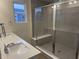 Modern bathroom featuring double vanity, quartz countertop, and an elegant glass-enclosed shower with a built-in bench at 7342 Shroyer Way, Noblesville, IN 46062