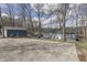 View of the house with gravel driveway surrounded by mature trees and lake in background at 7668 Heather Dr, Nineveh, IN 46164