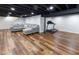 Finished basement with gray sectional, and a home treadmill, with wood-look flooring at 7811 Hoover Rd, Indianapolis, IN 46260