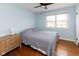 Bedroom with hardwood floors, a large window, and a comfortable bed with striped bedding at 7811 Hoover Rd, Indianapolis, IN 46260