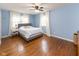 Comfortable bedroom with a queen bed, light blue walls, and lots of natural light at 7811 Hoover Rd, Indianapolis, IN 46260