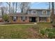Two-story brick home with blue accents, mature trees, and well-manicured front lawn at 7811 Hoover Rd, Indianapolis, IN 46260