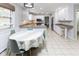 Eat-in kitchen with white cabinets and granite counters open to eating nook and seating at 7811 Hoover Rd, Indianapolis, IN 46260