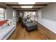Cozy living room with warm hardwood floors, exposed beams, and view into the modern kitchen at 7811 Hoover Rd, Indianapolis, IN 46260