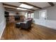 Inviting living room featuring hardwood floors, a brick fireplace, skylights, and neutral decor at 7811 Hoover Rd, Indianapolis, IN 46260