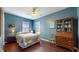 Bedroom featuring bright blue walls and vintage furniture; a wooden hutch with glass door sits in the corner at 7971 Cool Hollow Pl, Indianapolis, IN 46237