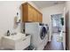 Functional laundry room with washer, dryer, sink, cabinets, and hardwood-style flooring at 7971 Cool Hollow Pl, Indianapolis, IN 46237